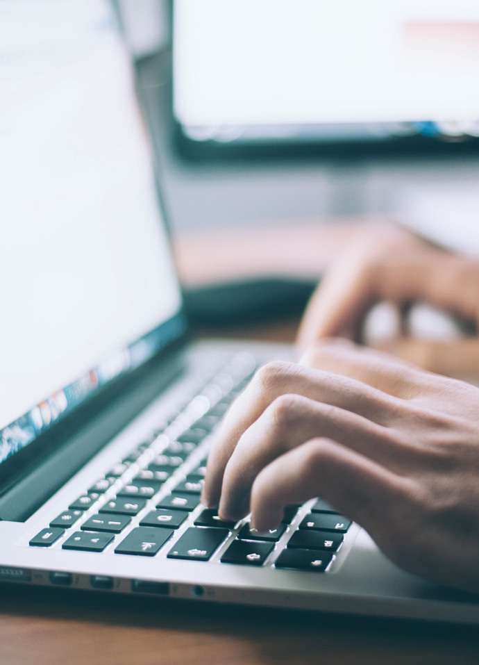 Digital marketer typing on a laptop in an agency office