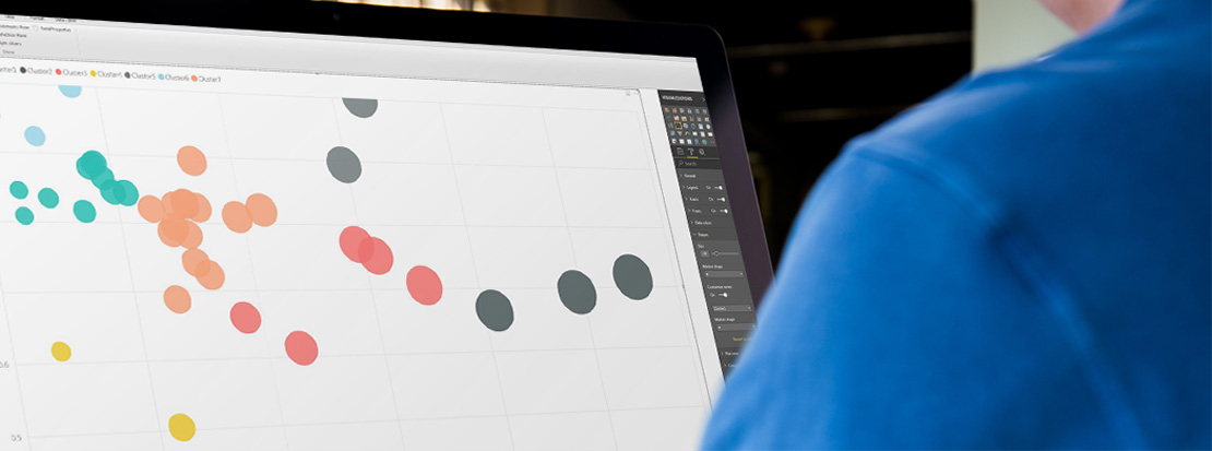 Marketing strategist performing cluster analysis at a desktop in a markeitng agency office